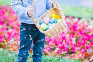 poco ragazzo con Pasqua uova nel busket su Pasqua all'aperto foto