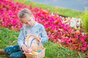 poco ragazzo con Pasqua uova nel busket su Pasqua seduta nel erba foto