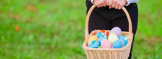 avvicinamento cestino pieno di colorato Pasqua uova nel bambini mani foto