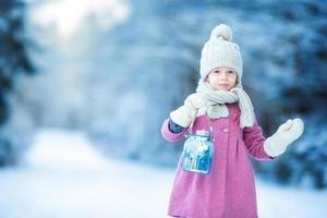 adorabile ragazza con lampada e candela nel inverno su natale vigilia all'aperto foto