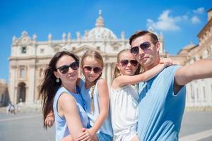 contento giovane famiglia assunzione autoscatto a st. di Pietro basilica Chiesa nel Vaticano città, Roma. contento viaggio genitori e bambini fabbricazione autoscatto foto immagine su europeo vacanza nel Italia.