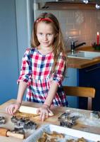 poco adorabile ragazza cottura al forno Natale biscotti a casa foto