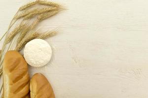 fatti in casa fresco pane con Grano orecchio su bianca legna tavolo. foto