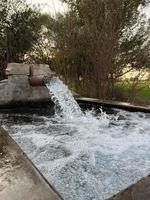 irrigazione acqua flusso a partire dal tubo per canale per agricoltura i campi foto