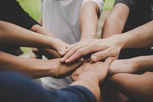 molte persone si uniscono per mano foto