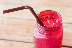 bevanda ghiacciata in vaso di vetro rosso con una cannuccia foto