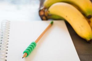 matita verde su un taccuino con frutta foto