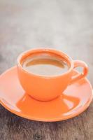 arancione tazza di caffè su un tavolo in legno rustico