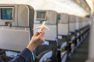 vicino su mano Tenere un aereo modello dentro un' grande aereo foto