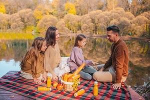 contento famiglia su un' picnic nel il parco a autunno foto