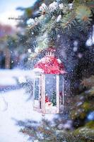 Natale lanterna con nevicata sospeso su un' abete ramo foto