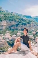 estate vacanza nel Italia. giovane uomo nel positano villaggio su il sfondo, amalfi costa, Italia foto