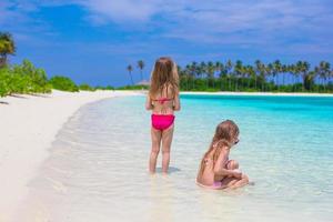 adorabili bambine che si divertono durante le vacanze al mare foto