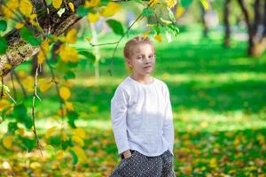 contento poco ragazza godere caldo giorno nel bellissimo autunno parco foto