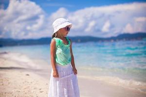 adorabile sorridente poco ragazza su tropicale vacanza nel bianca sabbioso spiaggia foto