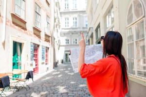 giovane donna con un' città carta geografica nel città. viaggio turista ragazza con carta geografica nel vienna all'aperto durante vacanze nel Europa. foto