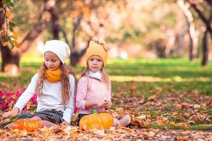 poco adorabile ragazze con zucca all'aperto su un' caldo autunno giorno. foto