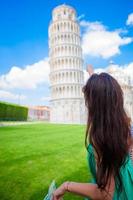 giovane contento ragazza con turistico carta geografica su viaggio per pisa. turista in viaggio visitare il pendente Torre di pisa. foto