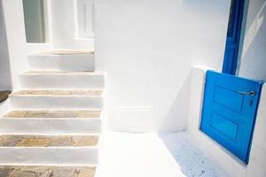tipico scala e un' piccolo blu porta su il accogliente strade di Mykonos, cicladi. foto
