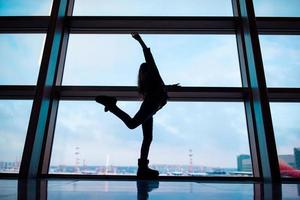 poco ragazza nel aeroporto vicino grande finestra mentre aspettare per imbarco foto