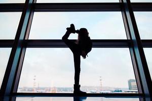 poco ragazza nel aeroporto vicino grande finestra mentre aspettare per imbarco foto