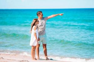 poco ragazza e contento papà avendo divertimento durante spiaggia vacanza foto