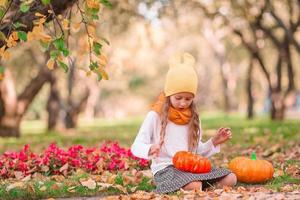 poco adorabile ragazza con zucca all'aperto su un' caldo autunno giorno. foto