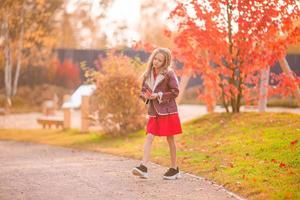 adorabile poco ragazza a bellissimo autunno giorno all'aperto foto