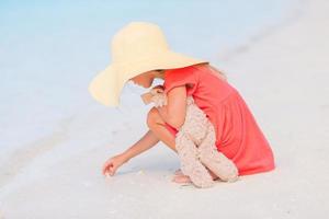 bambina adorabile che gioca sulla spiaggia con la palla foto