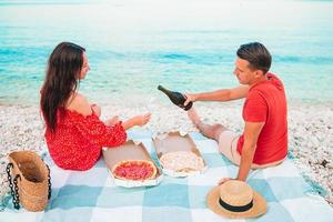 famiglia avendo un' picnic su il spiaggia foto