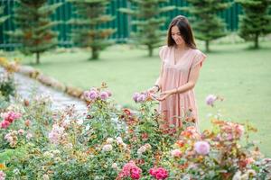 giovane ragazza nel un' fiore giardino tra bellissimo Rose. odore di Rose foto