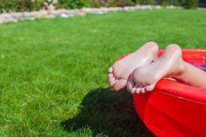 avvicinamento di un' poco ragazze gambe nel il piscina foto