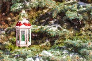 Natale lanterna con nevicata sospeso su un' abete ramo foto