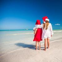 poco adorabile ragazze nel Santa cappelli durante spiaggia vacanza foto