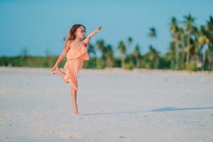 sorprendente poco ragazza a spiaggia avendo un' lotto di divertimento su estate vacanza. foto