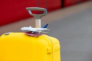 rosso passaporti e aereo piccolo modello su giallo bagaglio a treno stazione foto