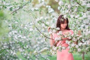 bellissimo donna godendo odore nel primavera ciliegia giardino foto