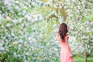 bellissimo donna godendo odore nel primavera ciliegia giardino foto