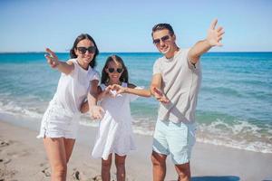 ritratto di famiglia di tre su il spiaggia foto