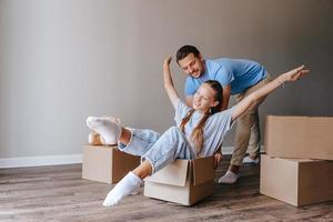 famiglia avere divertimento su in movimento giorno nel loro nuovo casa foto