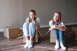 giovane adolescente ragazze in movimento nel nuovo Casa con cartone scatole foto