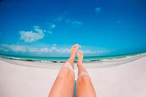 femmina piedi su bianca sabbioso spiaggia sfondo il mare foto