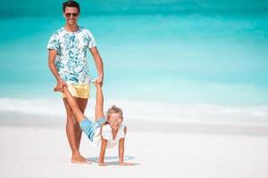 poco ragazza e contento papà avendo divertimento durante spiaggia vacanza foto