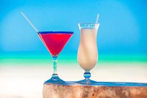 Due cocktail, Pina colada e fragola Margherita su bianca sabbia spiaggia foto