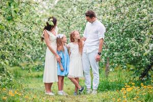 adorabile famiglia nel fioritura ciliegia giardino su bellissimo primavera giorno foto