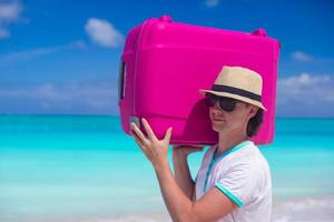 ritratto di un' giovane uomo trasporto il suo bagaglio su il spiaggia foto