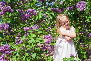 poco adorabile ragazza godendo bellissimo giorno nel fioritura giardino foto