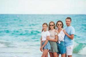 contento famiglia in posa su il spiaggia durante estate vacanza foto