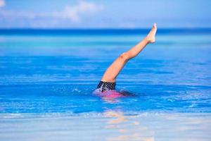 adorabile poco ragazza avendo divertimento nel all'aperto nuoto piscina foto