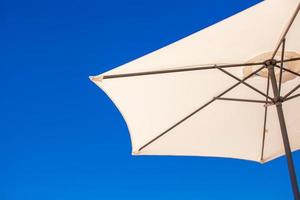 parte di bianca ombrello su sfondo blu cielo a il spiaggia